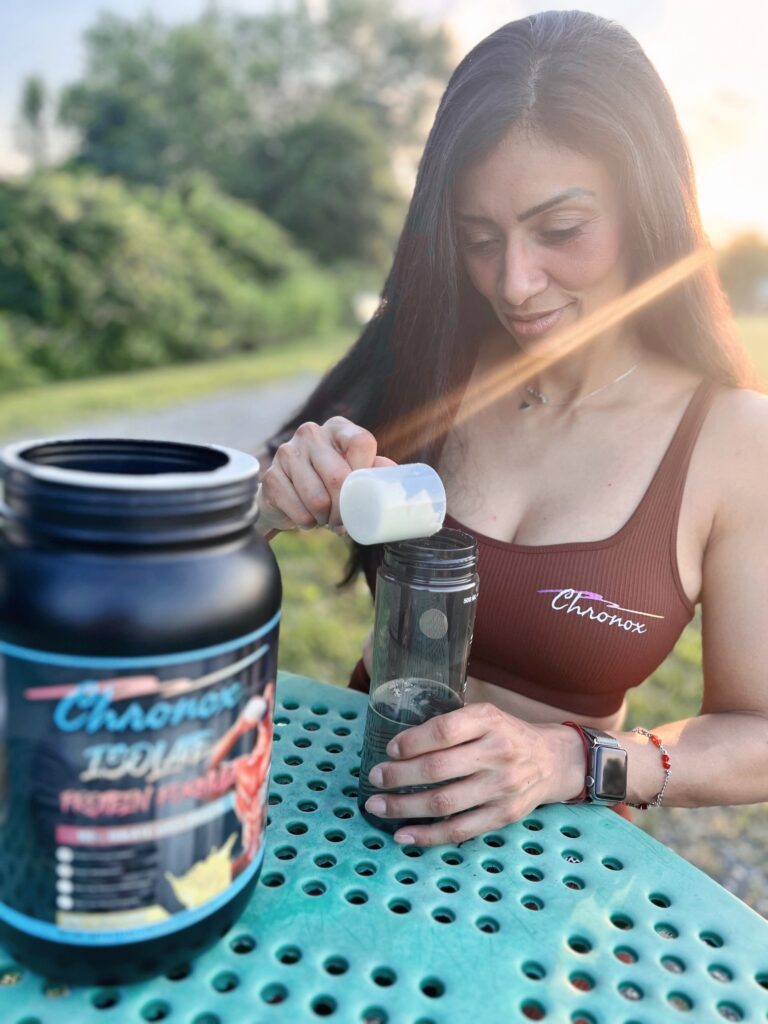 A Woman Adding Protein Powder into a Water Bottle